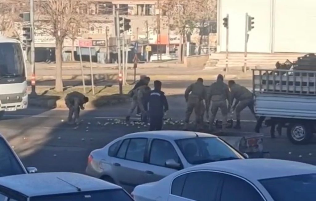 Yola saçılan elmaları, askerler elleriyle topladı